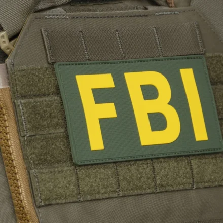 Close up of FBI patch on tactical vest during federal crypto investigation linked to alleged theft.