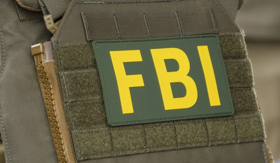 FBI Supervisory Agent Arrested for $1 Million Crypto Theft Close up of FBI patch on tactical vest during federal crypto investigation linked to alleged theft.