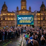Crowd celebrates Glasgow 2026 Commonwealth Games campaign conclusion in George Square at dusk. Joy!!