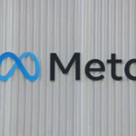 Meta logo displayed on a textured wall, representing WhatsApp scam detection and platform safety updates.