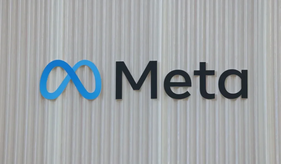 Meta logo displayed on a textured wall, representing WhatsApp scam detection and platform safety updates.