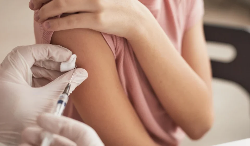 NHS Launches Massive Catch-Up Vaccine Campaign Young person receiving a meningitis vaccine in the upper arm during an NHS immunization appointment at clinic.