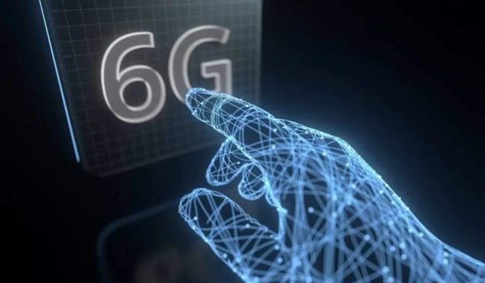 Futuristic AI hand reaching toward a glowing 6G display, representing future 6G mobile network tech.