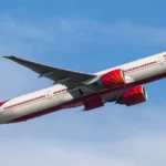 Air India passenger aircraft climbing into clear skies during an international flight to Delhi route.