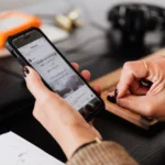 Person browsing social media on a smartphone at a desk during an interactive online campaign today.