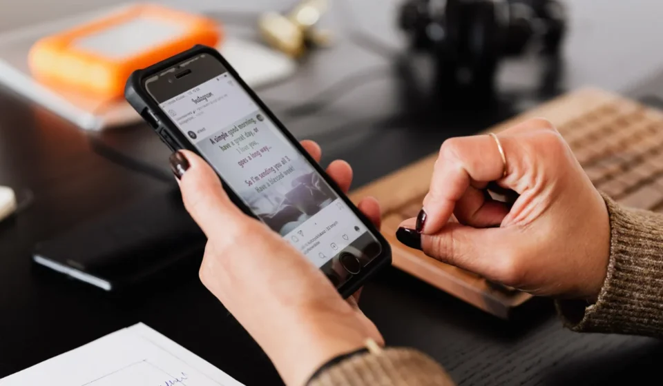 Social Networks Surge with Campaign Integration for Global Observances Person browsing social media on a smartphone at a desk during an interactive online campaign today.
