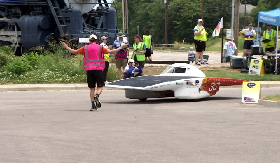 Student built solar car rounds a corner during the Electrek American Solar Challenge event on route.