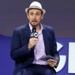 Randall Lane speaks into a microphone at the Global Citizen Now event.
