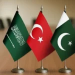 Saudi Arabia, Türkiye and Pakistan flags on a table, symbolizing the newly signed defense agreement.