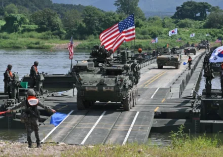 US and South Korean troops conduct a military exercise with armored vehicles crossing a river.