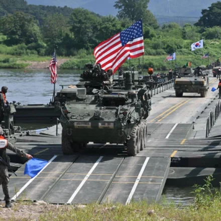 US and South Korean troops conduct a military exercise with armored vehicles crossing a river.