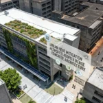 Concrete city buildings feature cool roofs, green walls, shaded walkways, trees, and solar panels.